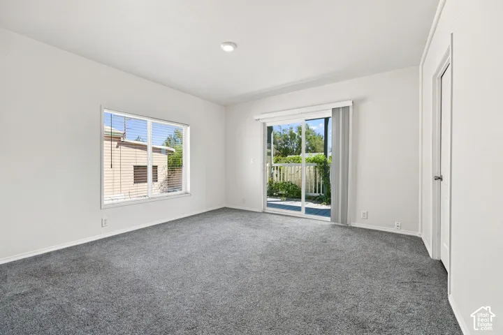 Bright, light-filled bedroom featuring neutral wall finishes, recessed ceiling lighting, and plush carpeting throughout
