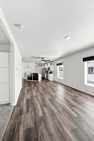 Open-concept living space featuring wood-finish flooring, white walls, and recessed lighting