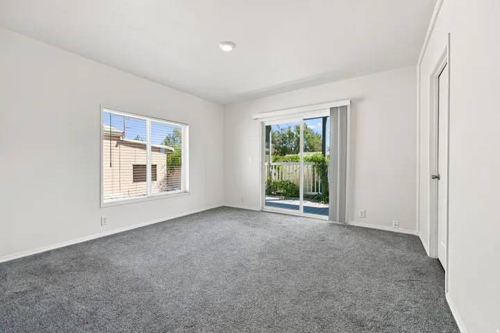 Bright, light-filled bedroom featuring neutral wall finishes, recessed ceiling lighting, and plush carpeting throughout