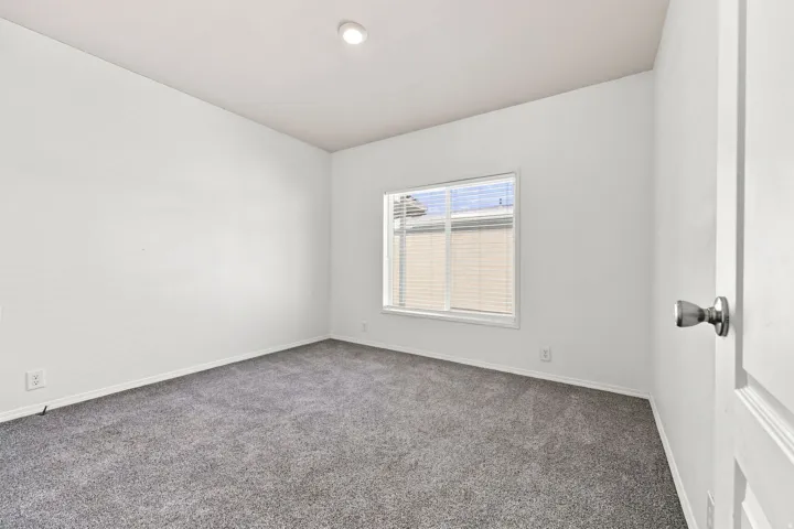 Neutral wall finish, carpeted flooring, recessed lighting, and a window with blinds