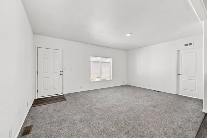 Neutral wall finishes, contemporary gray carpeting, recessed ceiling light, paneled interior doors, and a window with blinds
