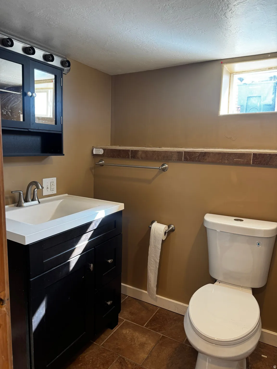 Dark wood-finish vanity with an integrated white sink and brushed nickel faucet