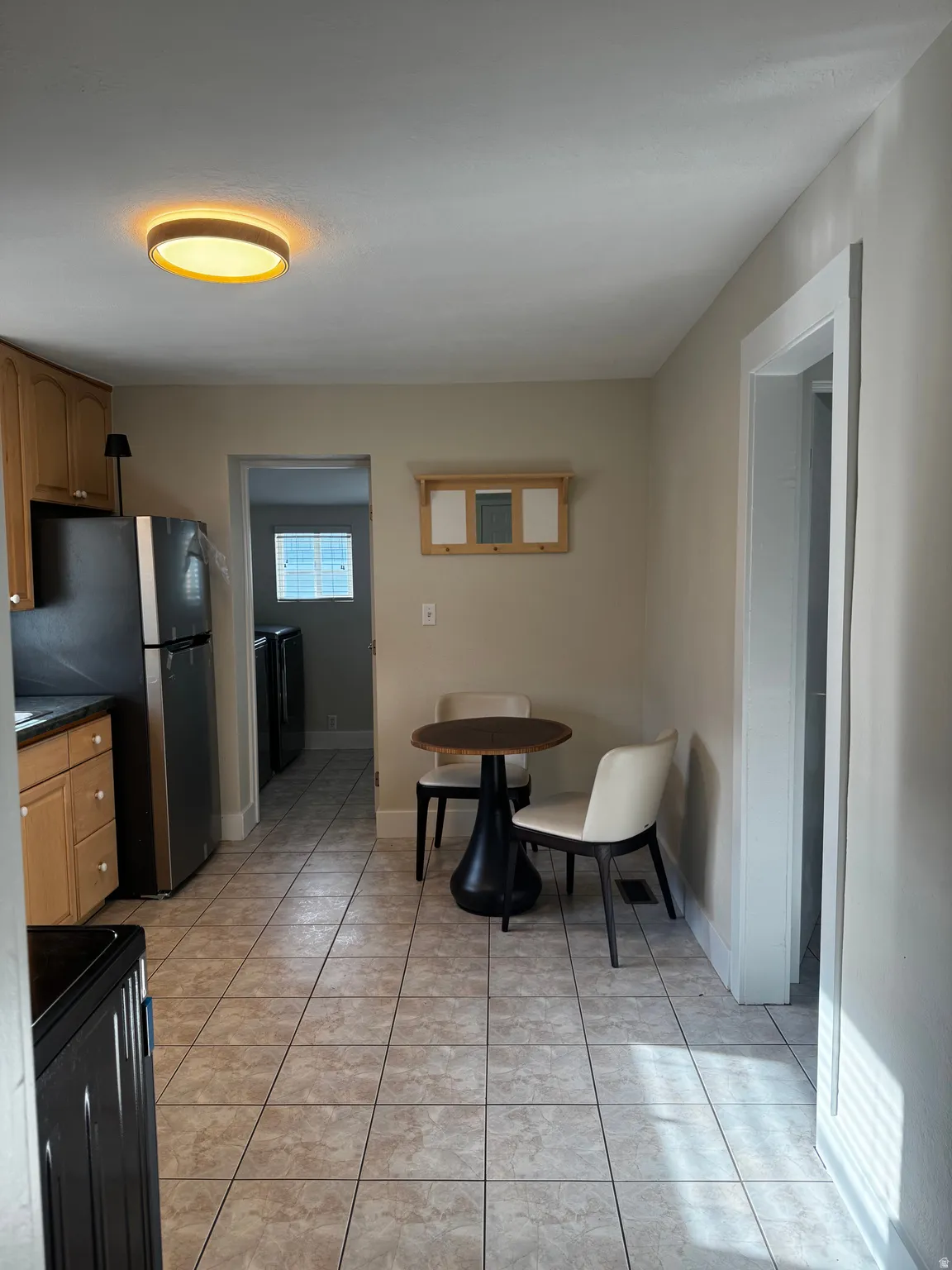 Kitchen featuring tile flooring, wood cabinetry, and stainless steel appliances