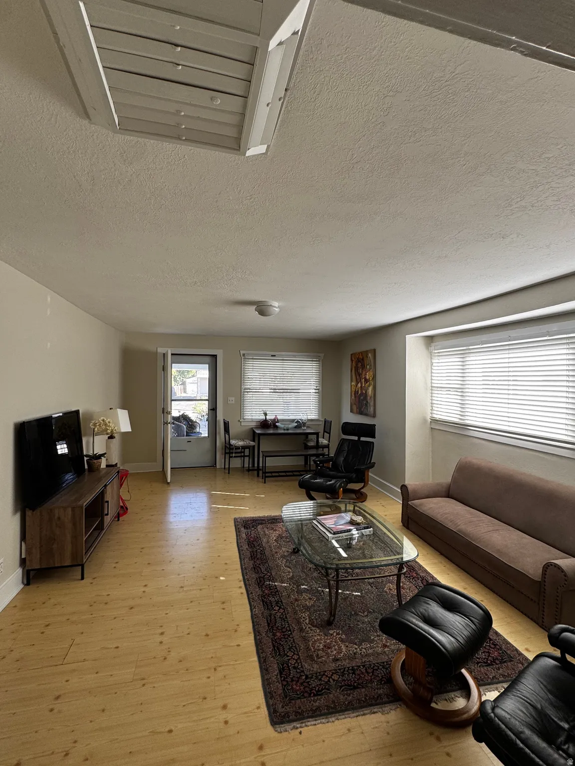 Wood-finish flooring throughout, recessed lighting, and a white ceiling with an attic access panel