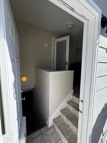 Entryway featuring tile flooring, a half wall, and a frosted glass interior door