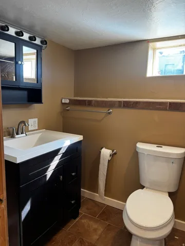 Dark wood-finish vanity with an integrated white sink and brushed nickel faucet