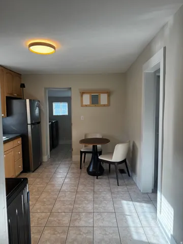 Kitchen featuring tile flooring, wood cabinetry, and stainless steel appliances