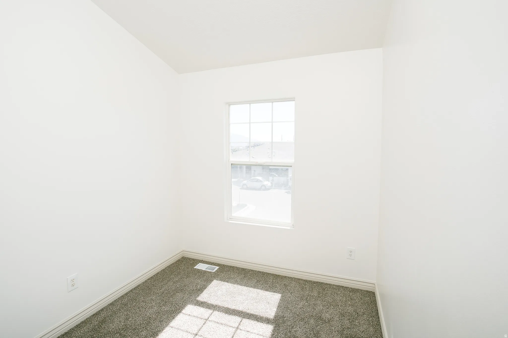 Neutral-toned carpet flooring with white baseboards and walls