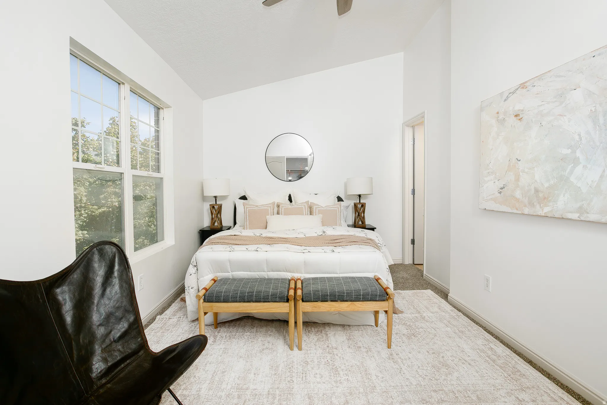Vaulted ceiling, large double-hung window, recessed doorway, and carpet flooring