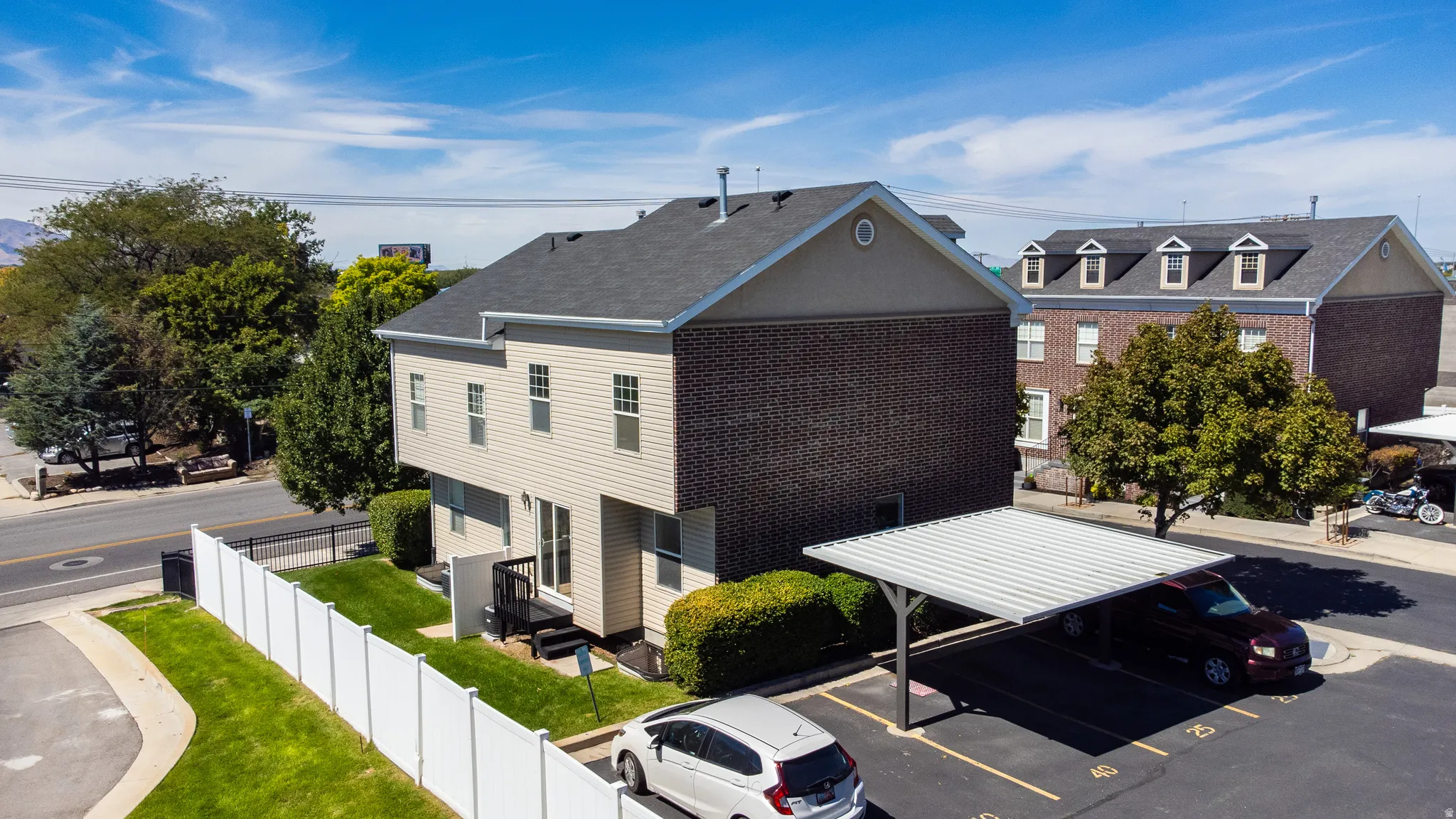 Multi-level building with brick and siding exterior, private rear deck, and fenced yard