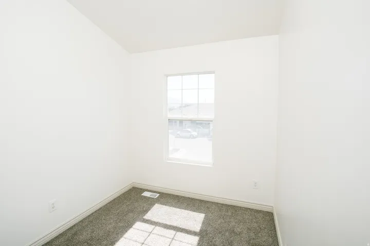 Neutral-toned carpet flooring with white baseboards and walls
