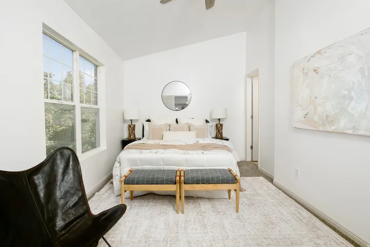 Vaulted ceiling, large double-hung window, recessed doorway, and carpet flooring