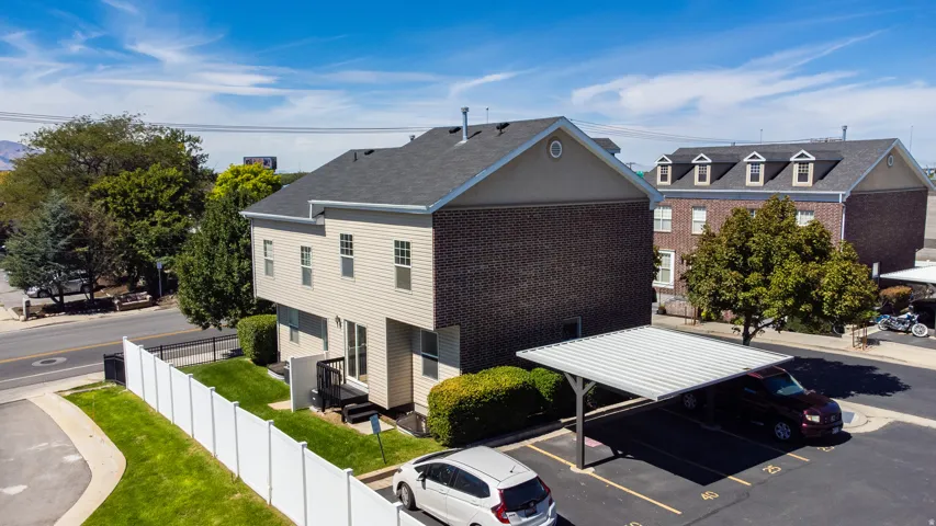 Multi-level building with brick and siding exterior, private rear deck, and fenced yard