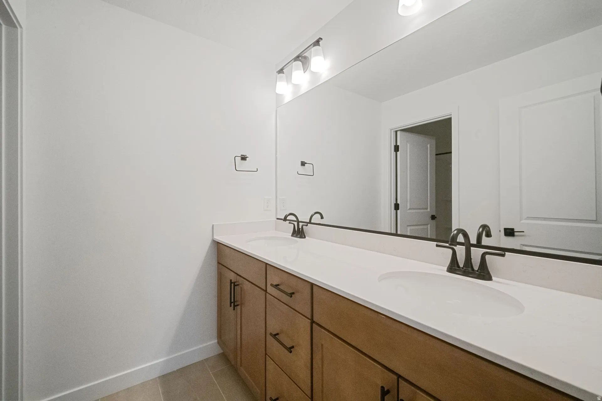 Dual vanity with white countertop, undermount sinks, and matte black fixtures
