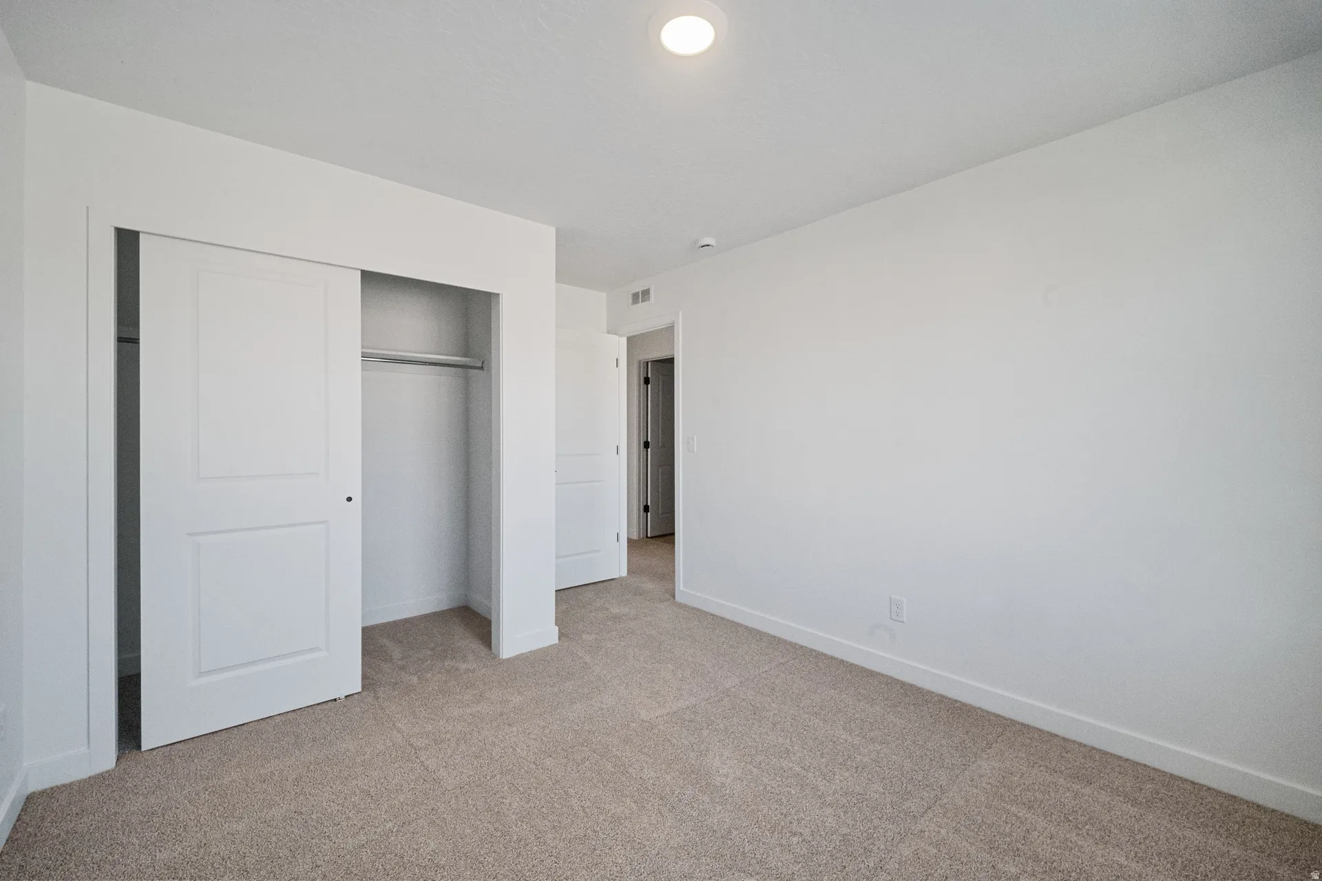 Neutral-toned carpet flooring and white walls