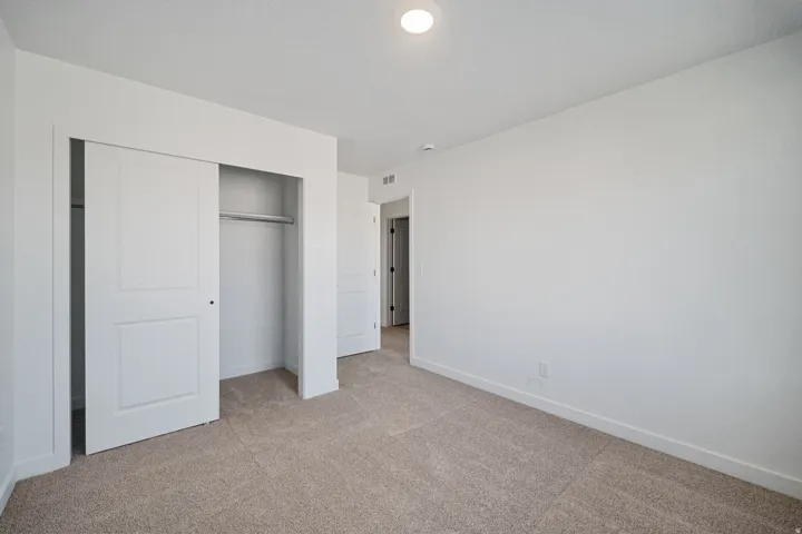 Neutral-toned carpet flooring and white walls