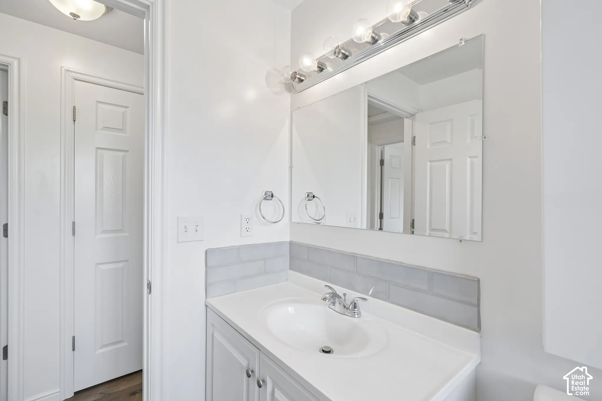 Vanity with integrated sink, chrome faucet, and white cabinetry