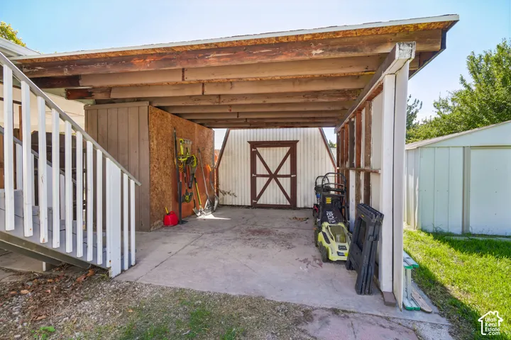 Carport structure with a concrete pad and exposed wood beams