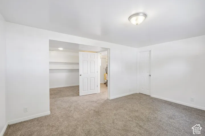 Plush carpeting, bright white walls, and a flush-mount ceiling light fixture