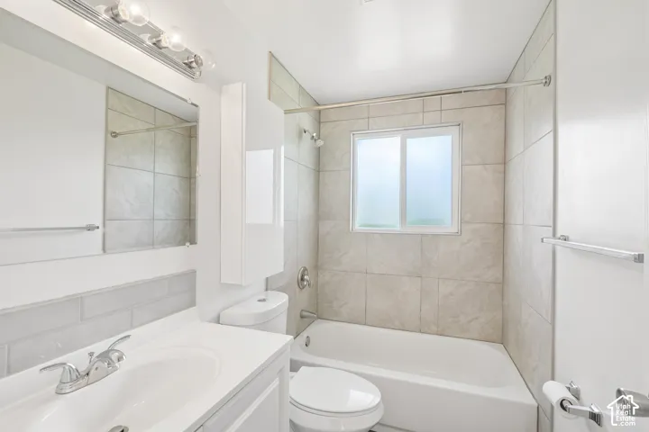 Bathroom with a single vanity, undermount sink, chrome faucet, and subway tile backsplash