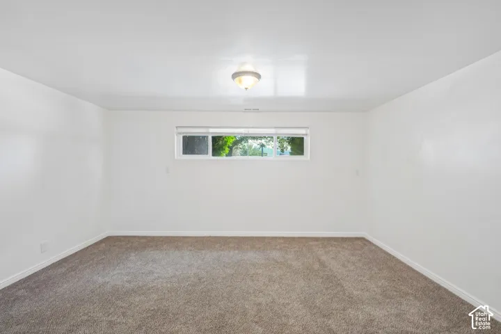 Recessed window with white trim, tan carpet, and a ceiling-mounted light fixture