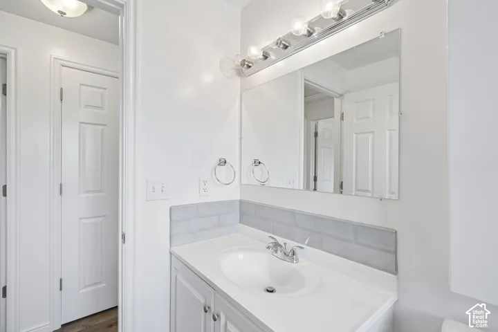 Vanity with integrated sink, chrome faucet, and white cabinetry