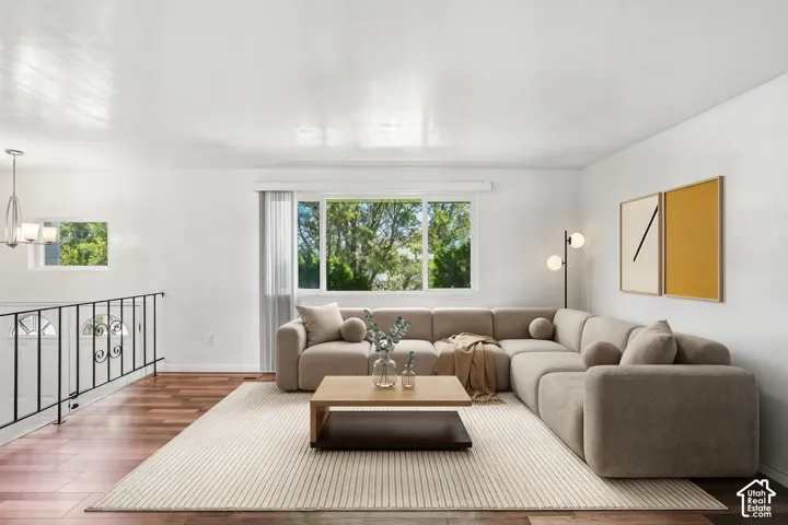 Expansive living area featuring wood-finish flooring, a large picture window, and white wall finishes