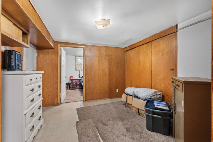 Wood-paneled room featuring built-in shelving, a flush-mount ceiling light, and a white interior door