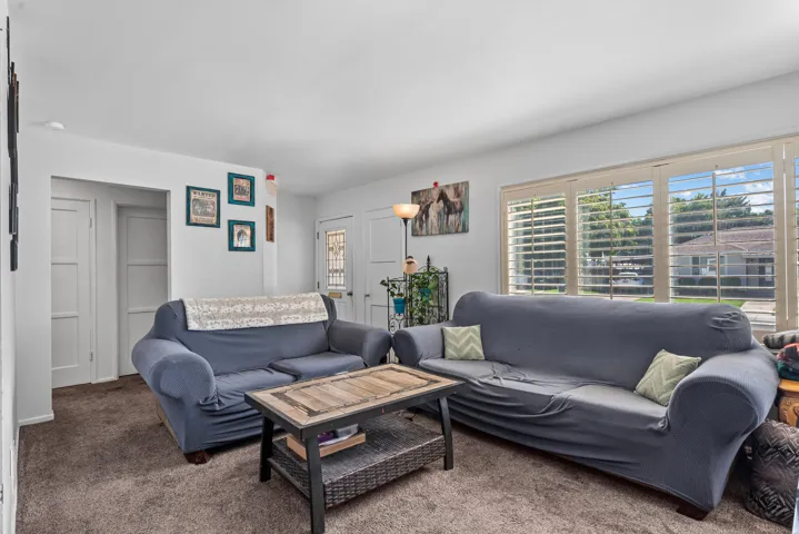 Bright interior space with large windows featuring plantation shutters