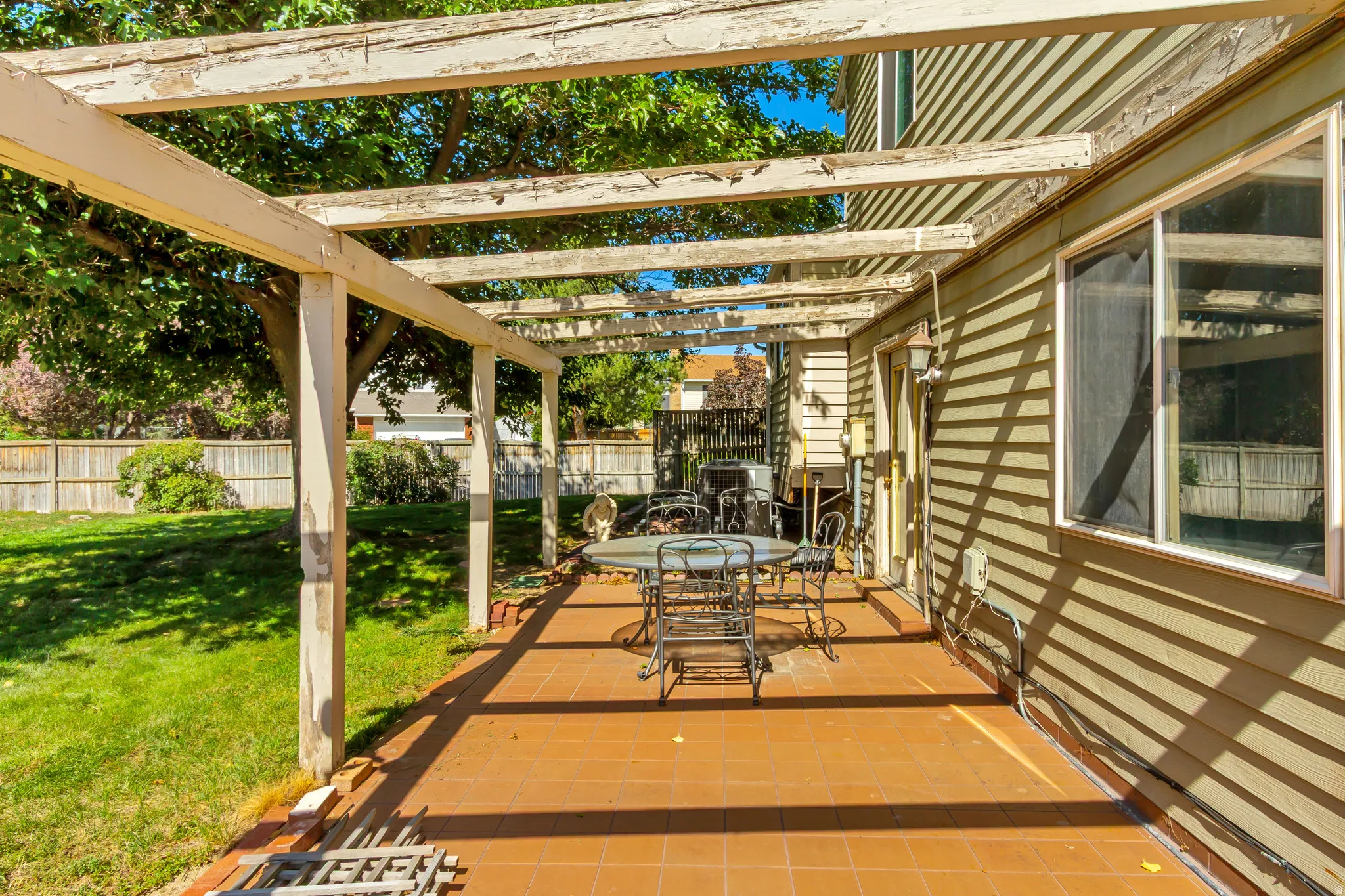 Patio with terracotta-colored tile flooring, wood pergola, and direct access to the interior