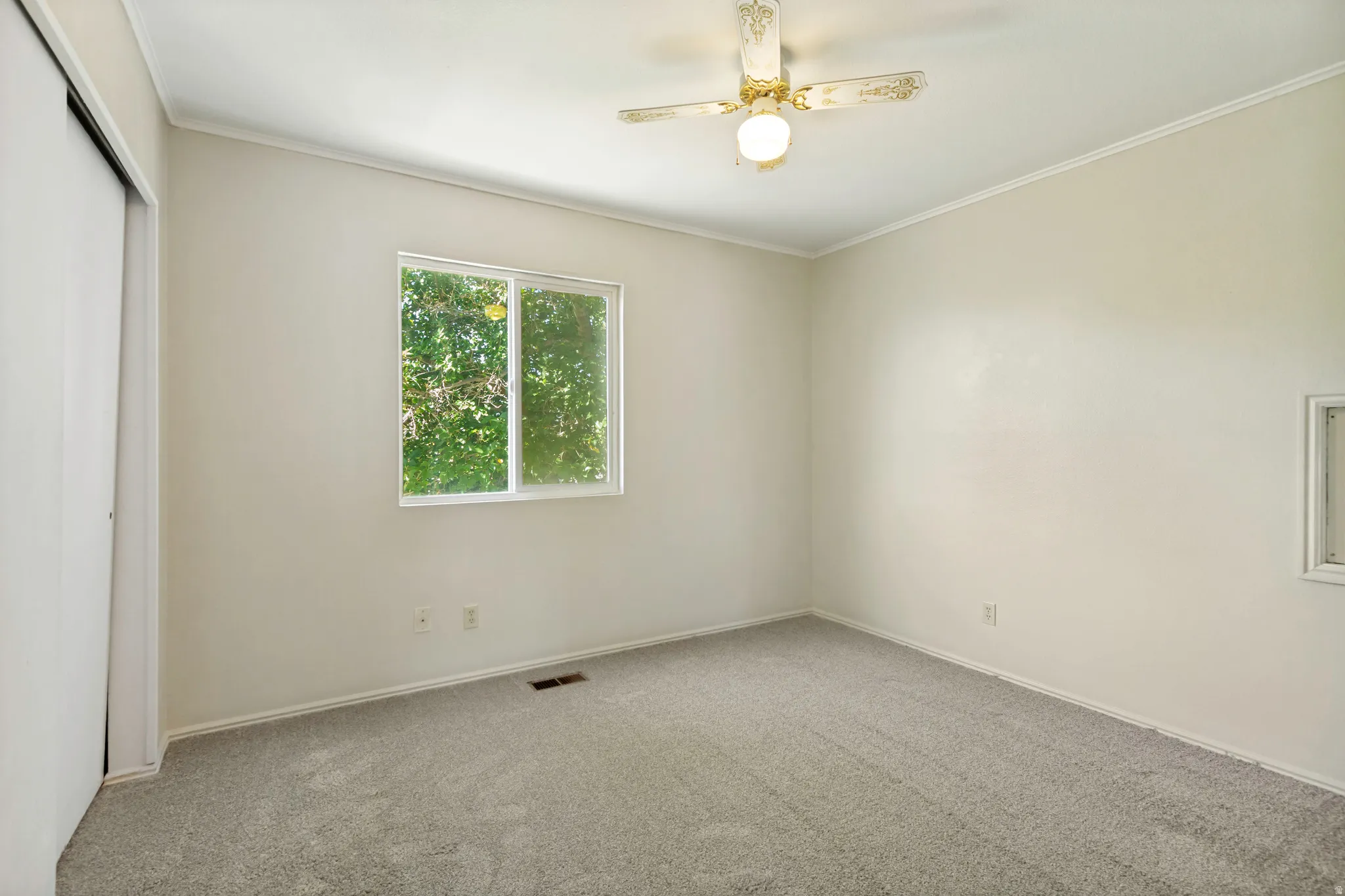 Secondary  Bedroom - Carpeted room featuring a ceiling fan, a window, and sliding closet doors
