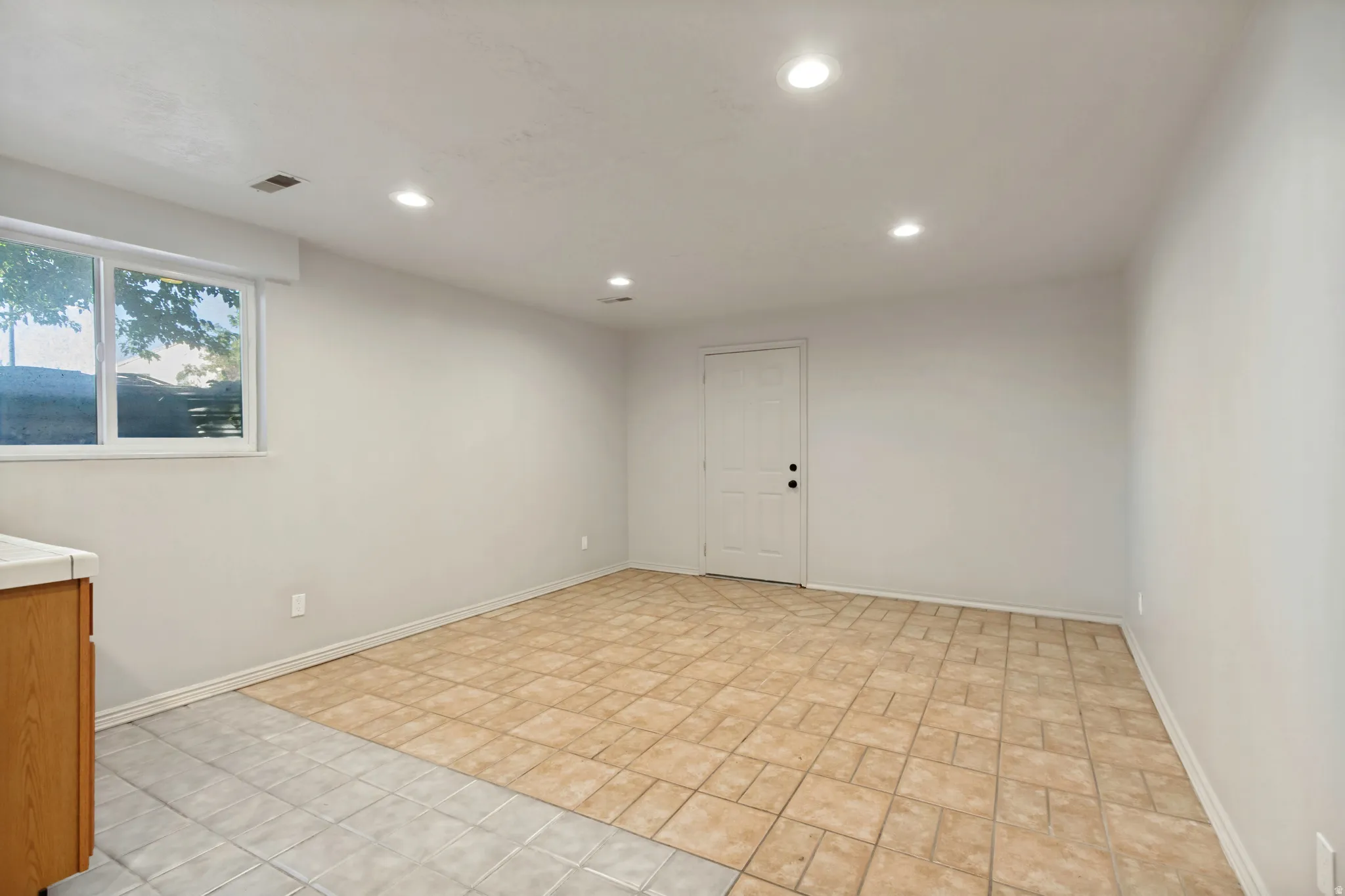 ADU - Recessed lighting illuminates the tiled flooring and light-toned walls