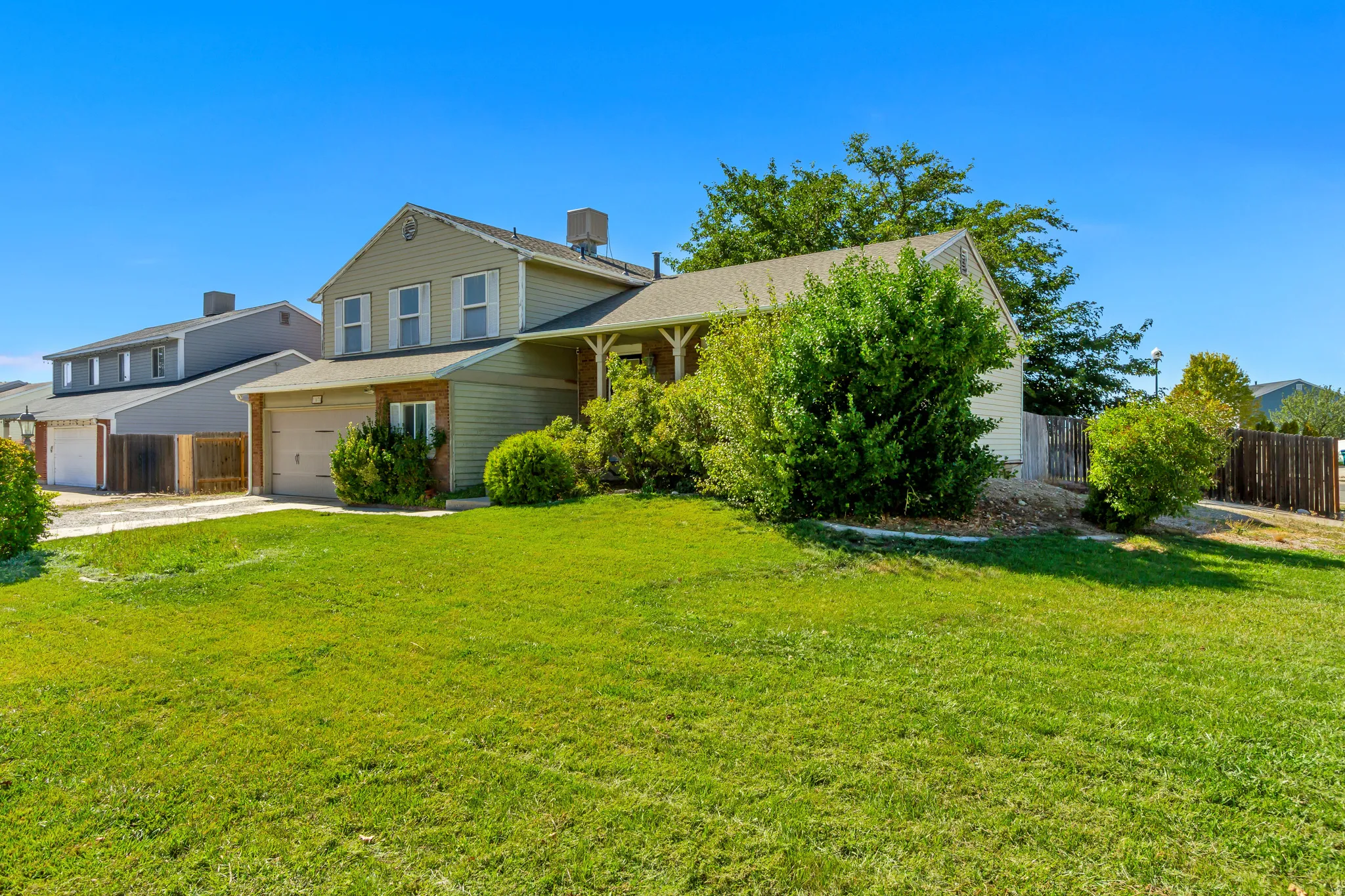 Side Yard - Two-story residence with an attached two-car garage, featuring a gabled roof and exterior siding