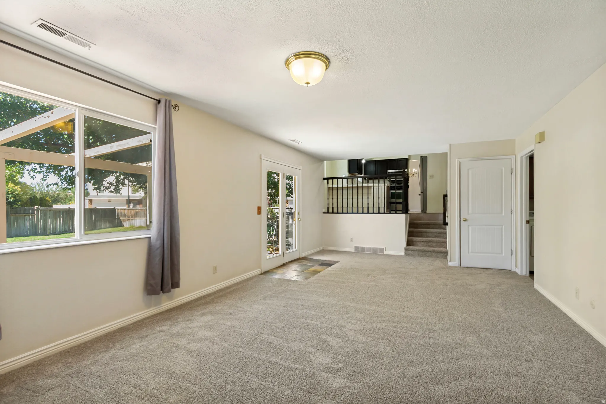 Carpeted living area with white walls and a white ceiling