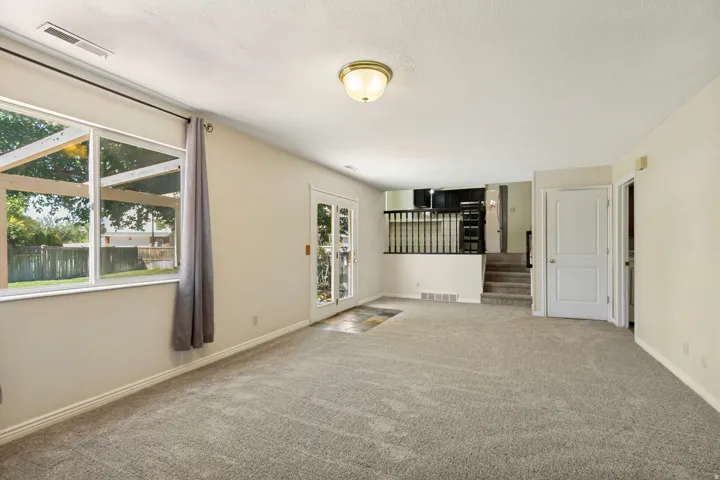 Carpeted living area with white walls and a white ceiling