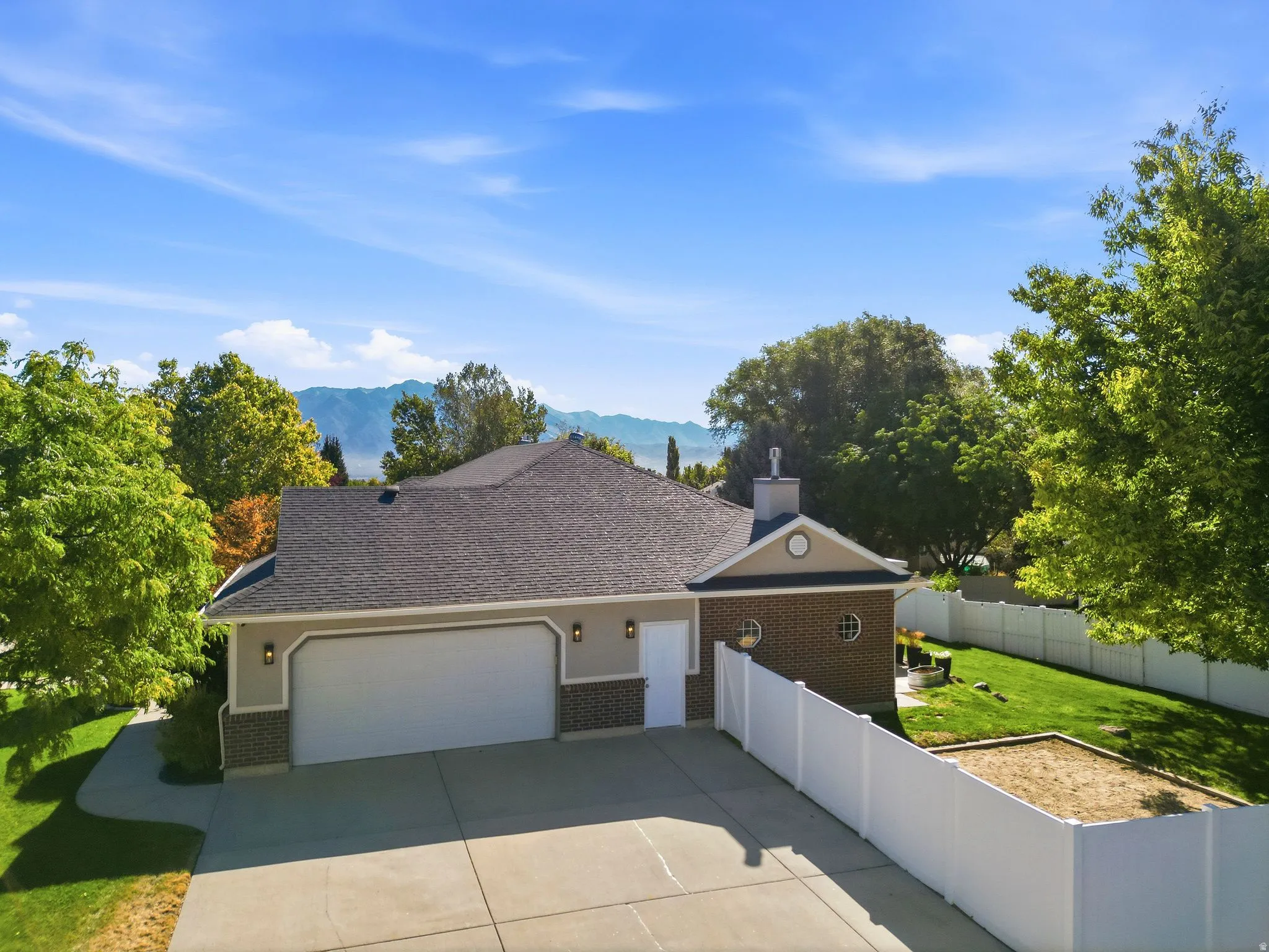 Single-story residence featuring a two-car garage, brick and stucco exterior, and a well-maintained roof