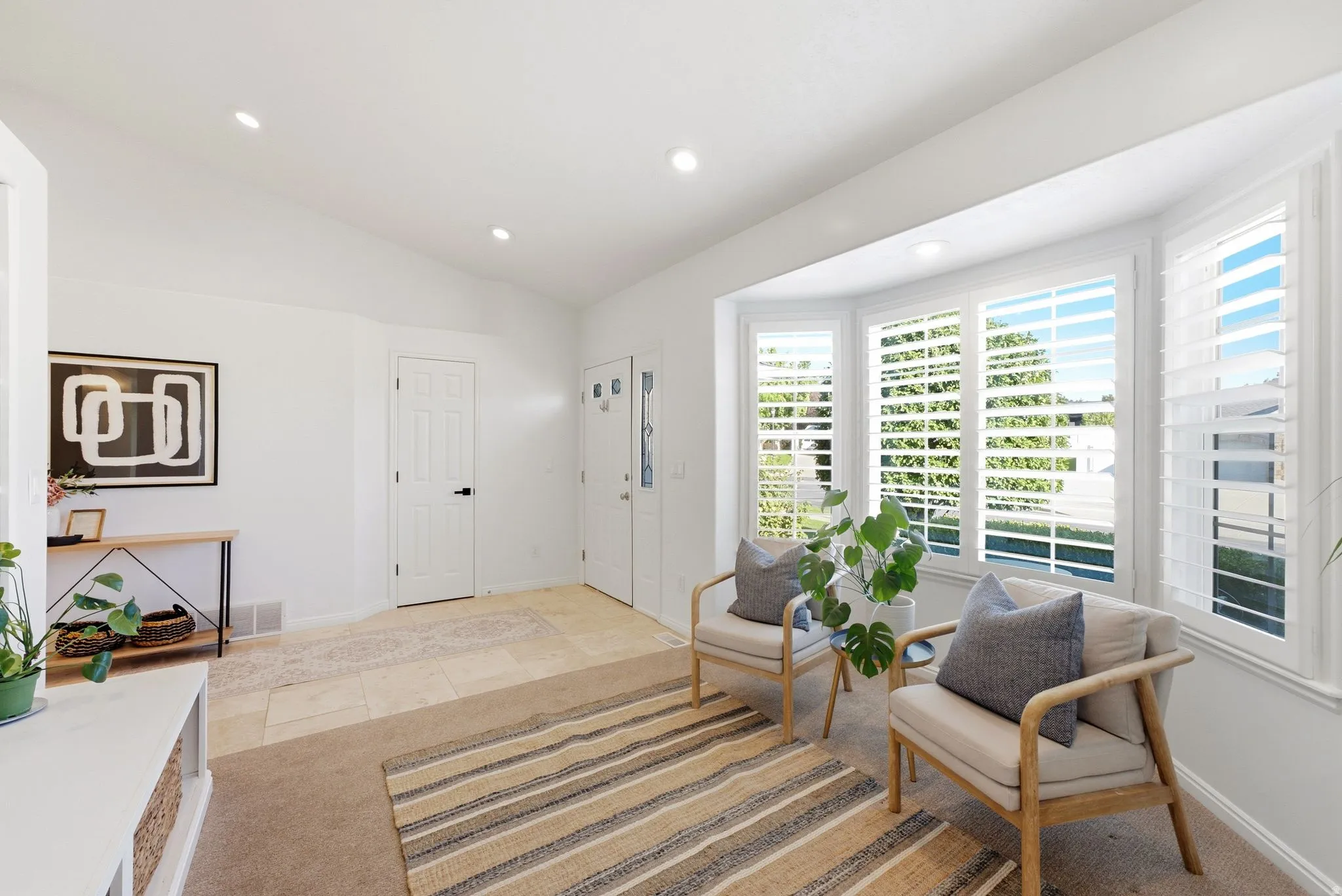 Bay window with plantation shutters, recessed lighting, vaulted ceiling, white paneled doors, and tiled flooring