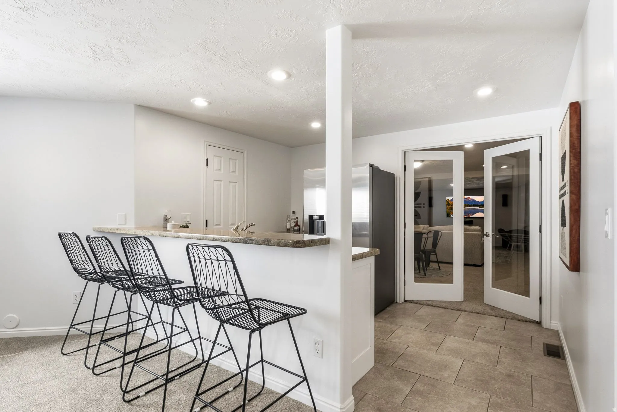 Breakfast bar with a light-colored countertop, recessed lighting, and a built-in sink