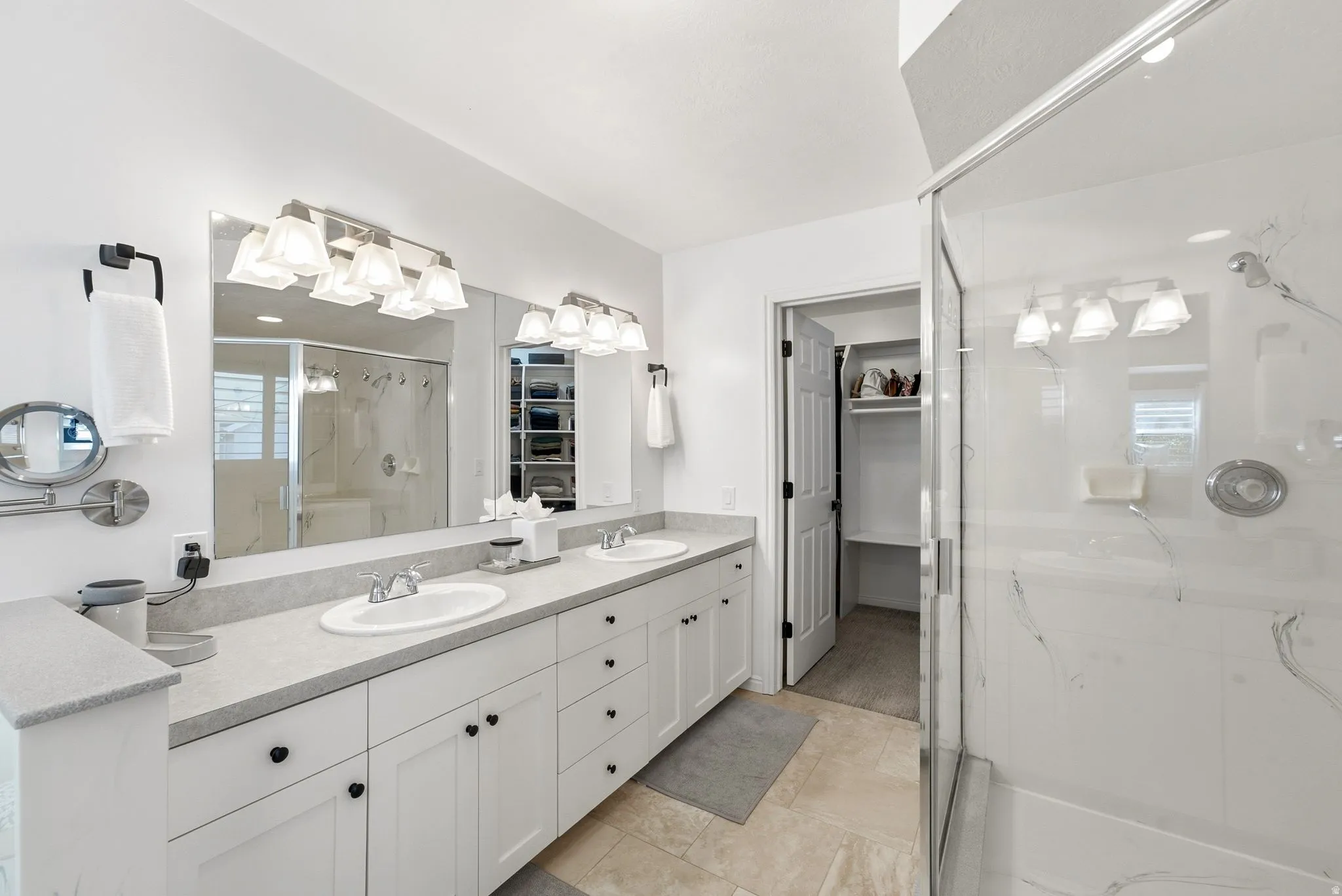 Dual vanity with white cabinetry, light countertops, and individual sinks