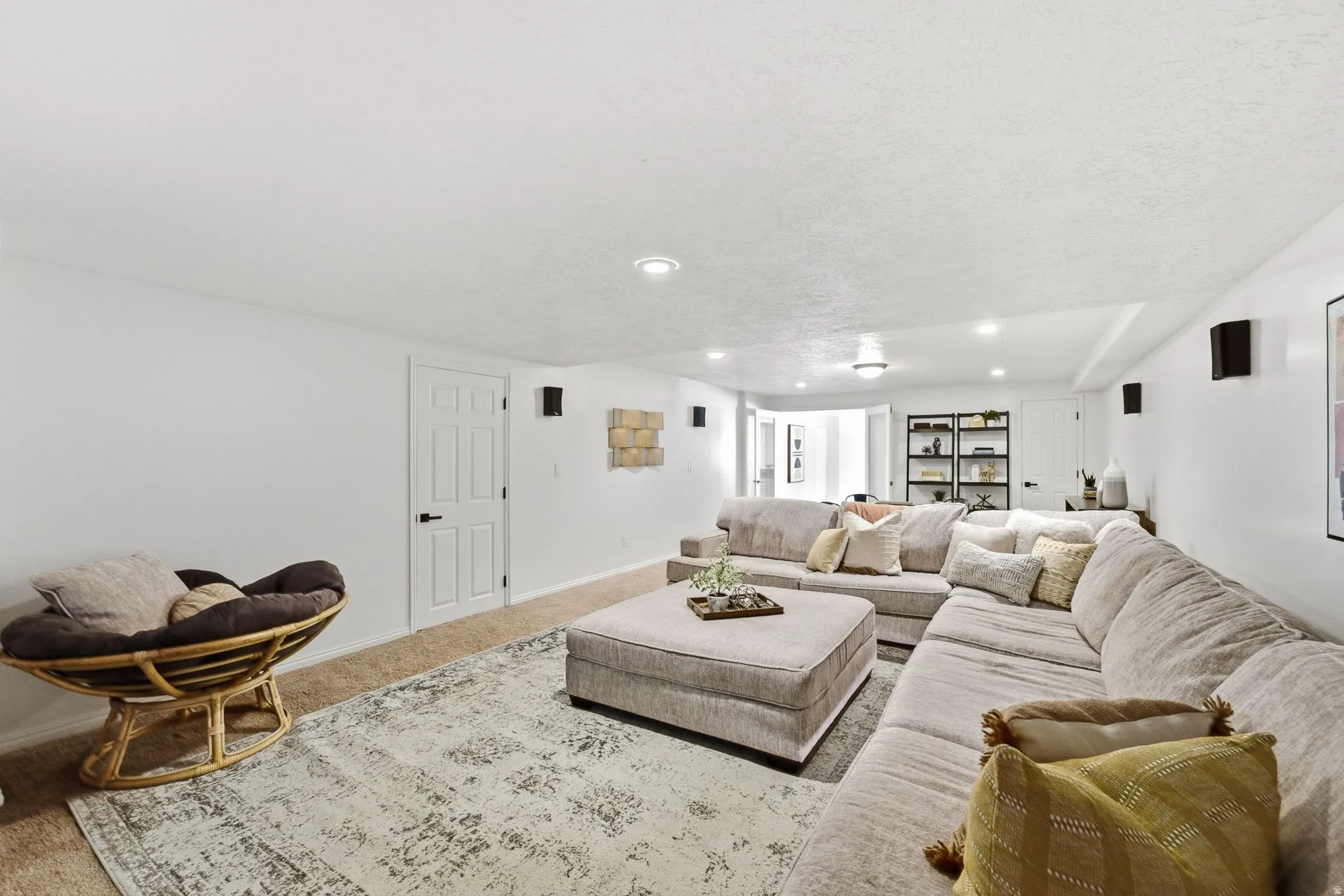 Recessed lighting, white paneled doors, built-in shelving, wall-mounted speakers, and carpet flooring