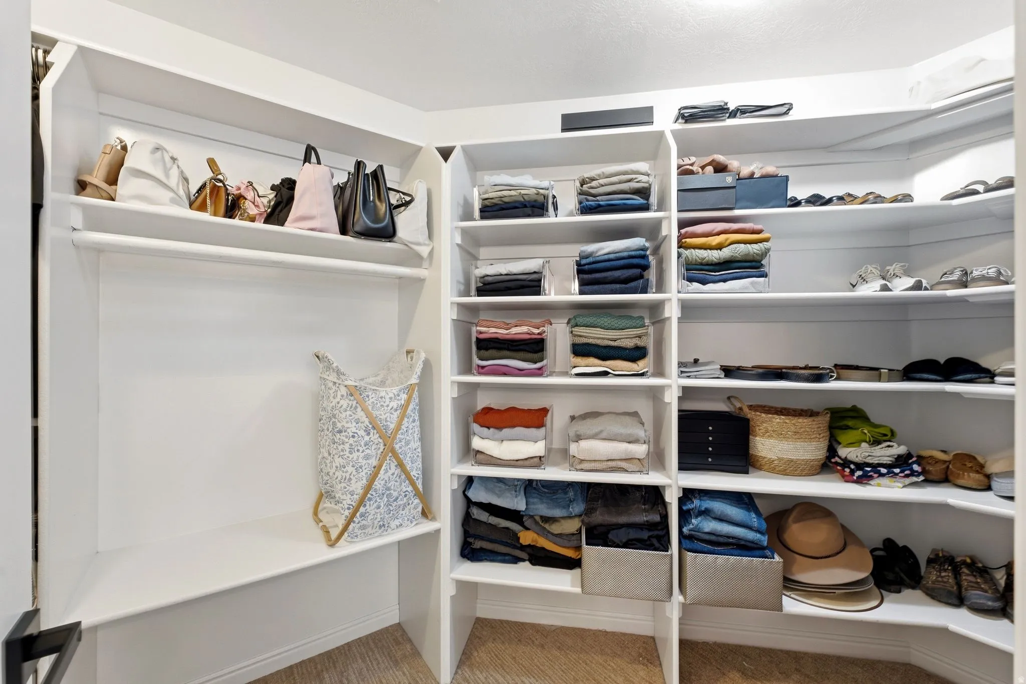 Built-in closet system featuring white shelving, multiple storage compartments, and a clothing rod