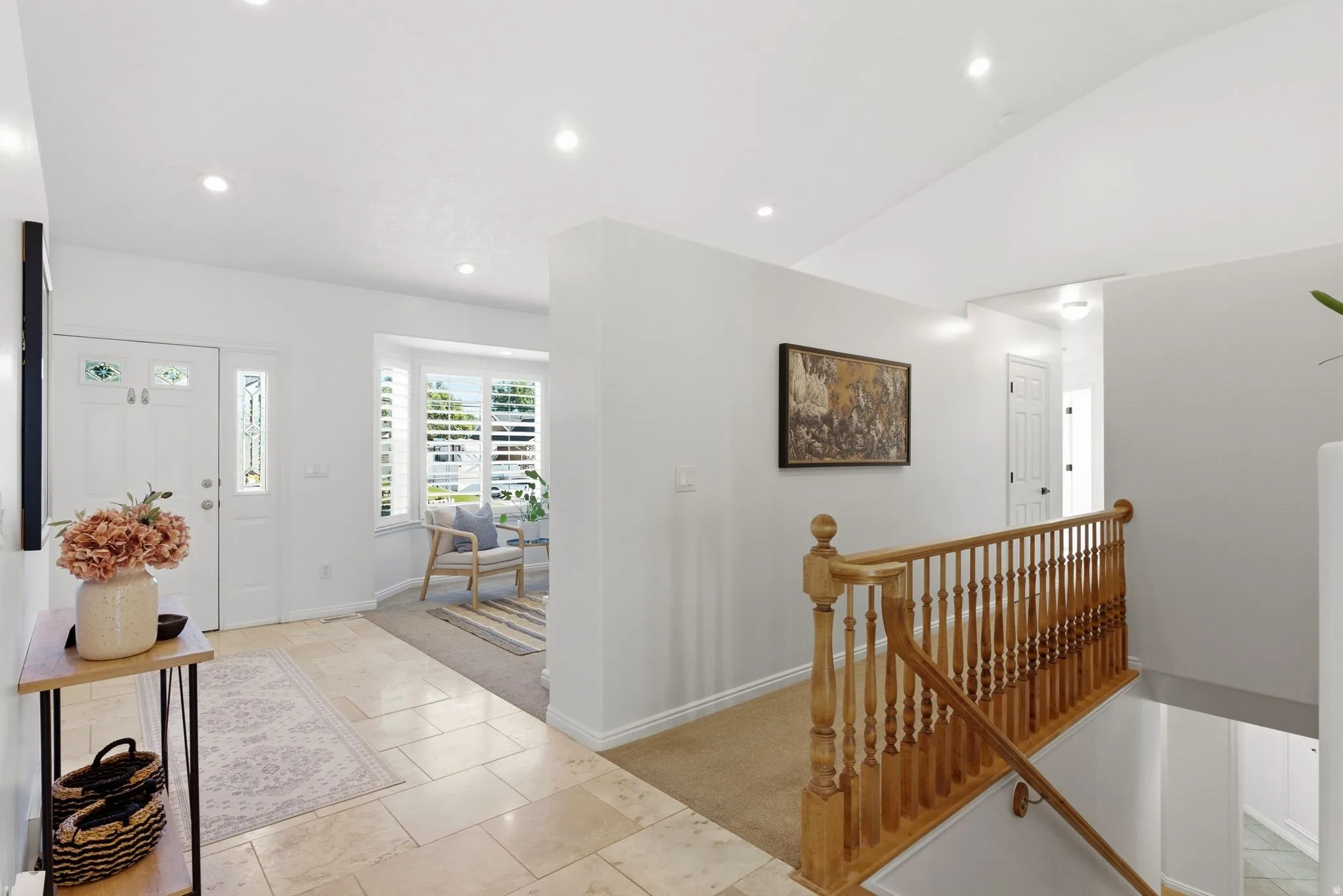 Recessed lighting illuminates the entryway with large format tile flooring
