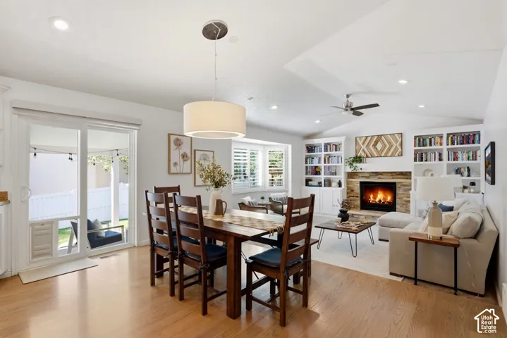 Hardwood-finish flooring, recessed lighting, and a stone-surround fireplace with a wood mantle