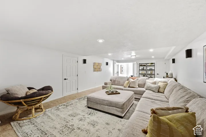 Recessed lighting, white paneled doors, built-in shelving, wall-mounted speakers, and carpet flooring