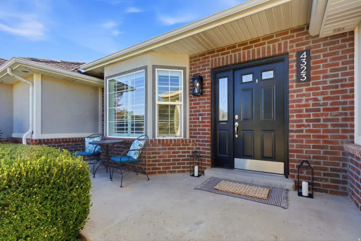 Brick exterior detailing a black entry door with transom windows
