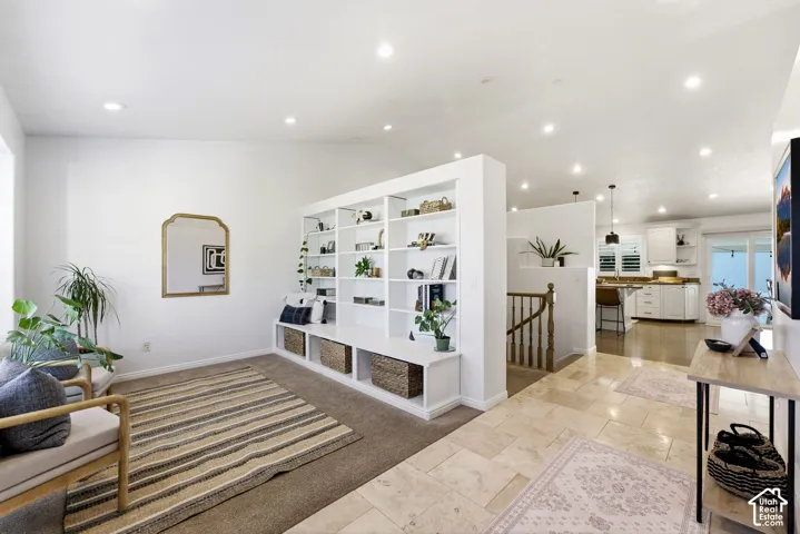Built-in shelving unit with lower storage, recessed ceiling lighting, light-toned wall paint, and a tiled entryway