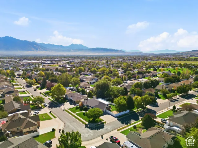 Expansive residential neighborhood with mature trees, green spaces, and mountain scenery