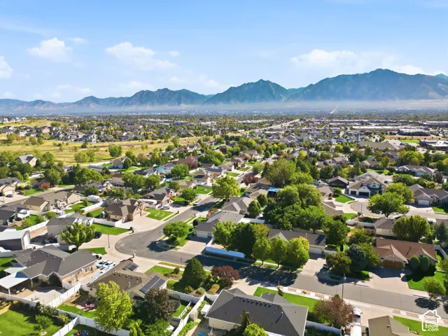 Residential neighborhood with established homes, mature trees, and mountainous scenery