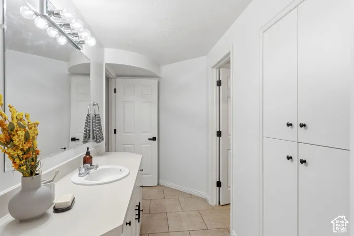 Vanity with an integrated sink, polished chrome faucet, and overhead bar lighting