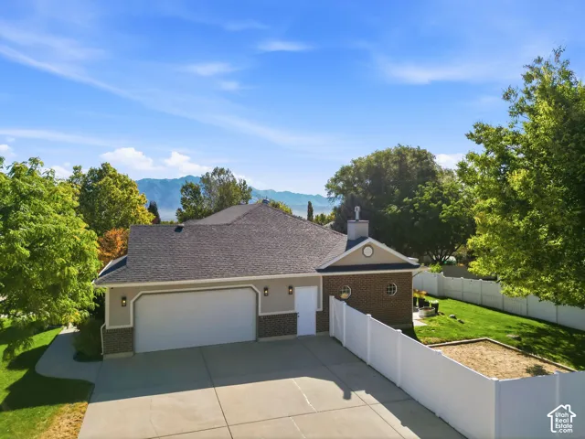 Single-story residence featuring a two-car garage, brick and stucco exterior, and a well-maintained roof